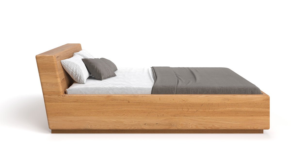 Designer Holzbett Calveno aus massiver Eiche mit Stauraum und geneigtem Headboard